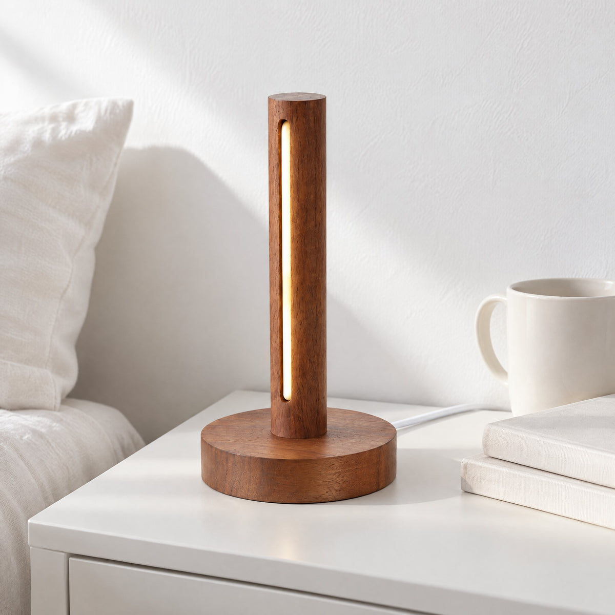 Ember walnut lamp glowing on a white bedside shelf