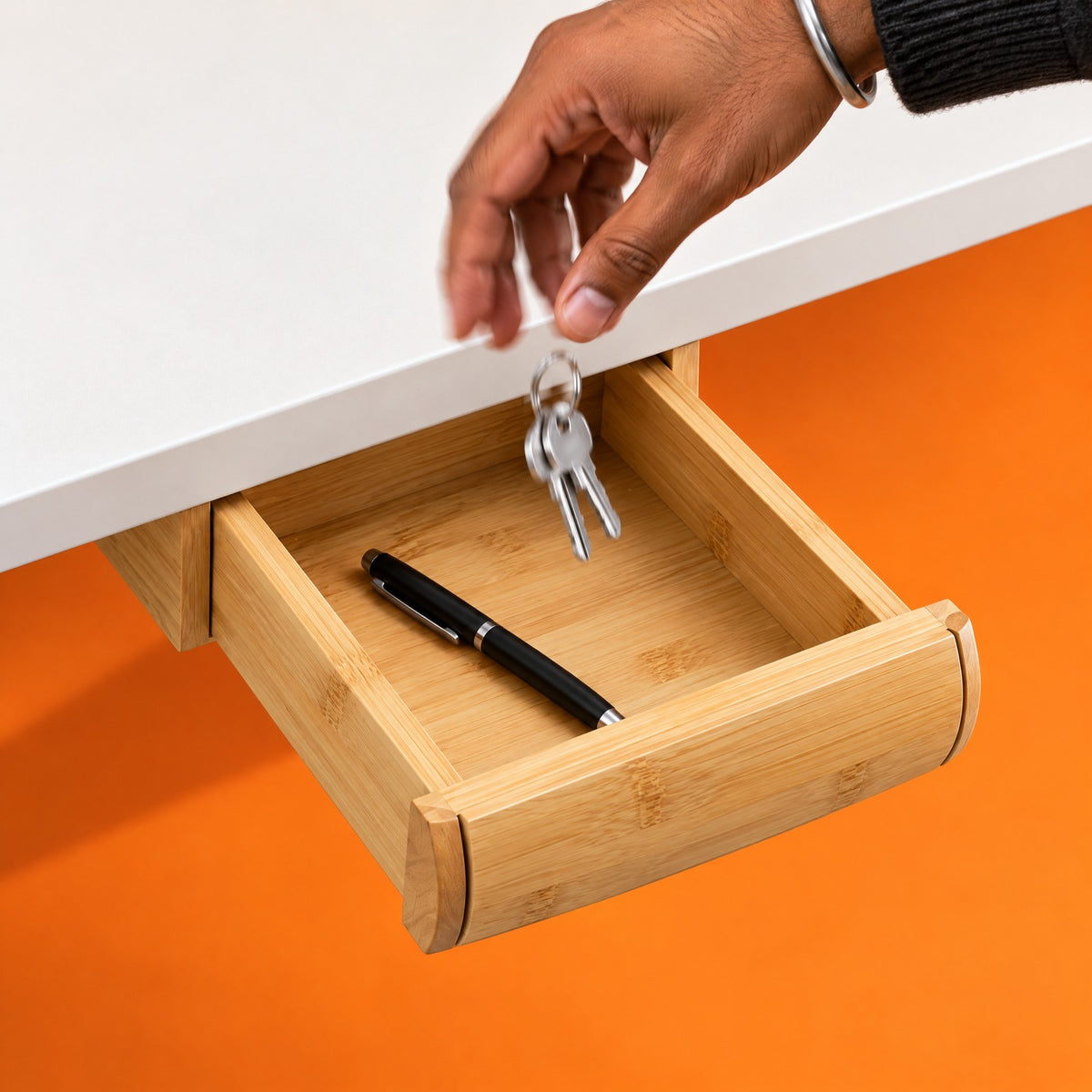 Keys dropping into the bamboo Glide drawer, pulled out from under a white desk