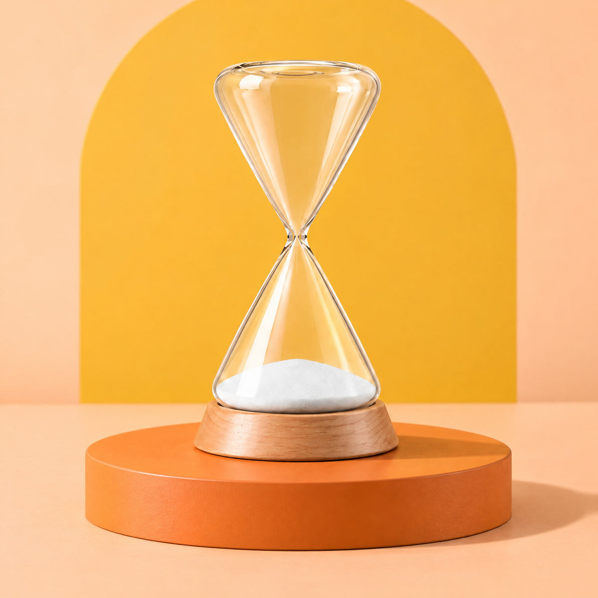 Ebb glass hourglass in its beech base on a low orange podium against a peach and yellow backdrop