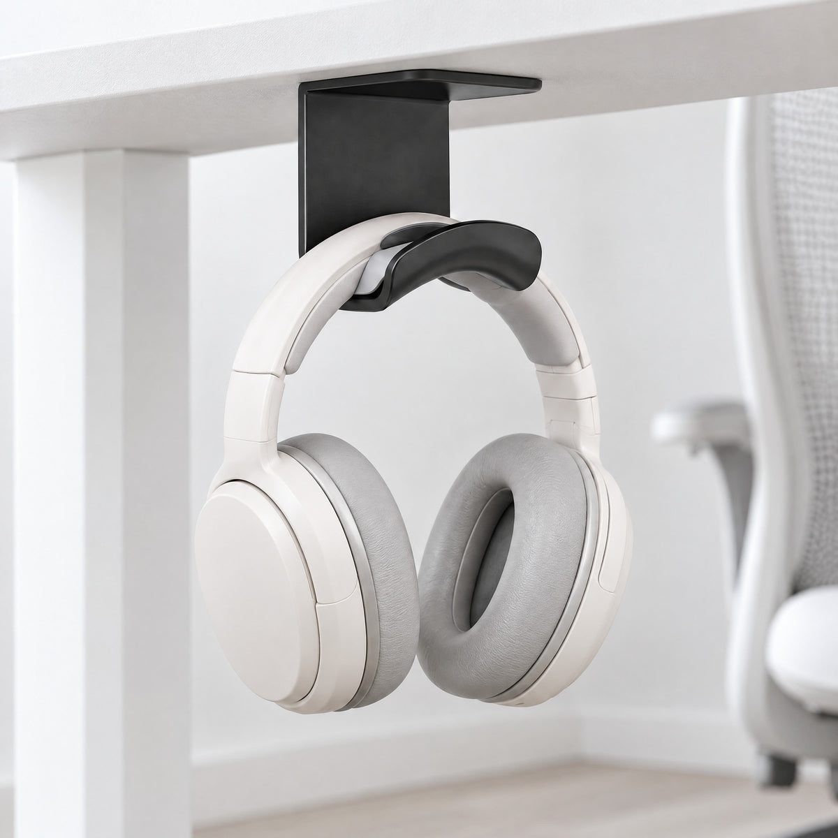 Black Eave under-desk headphone hook holding white headphones beneath a white desk