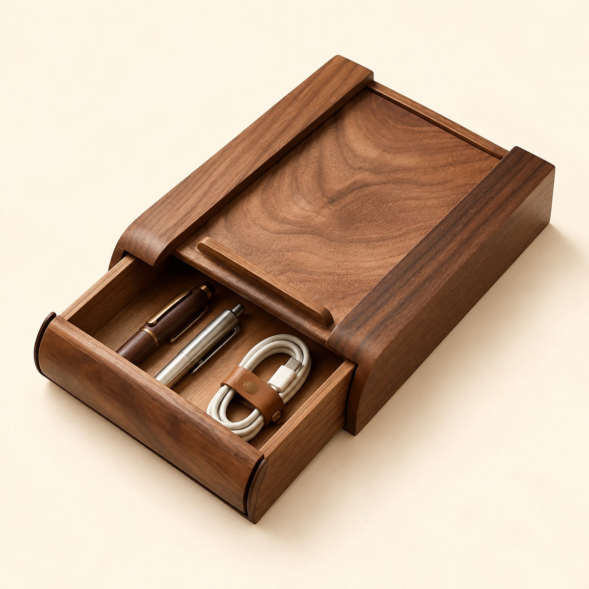 Walnut under-desk drawer, half open, with pens and a cable inside