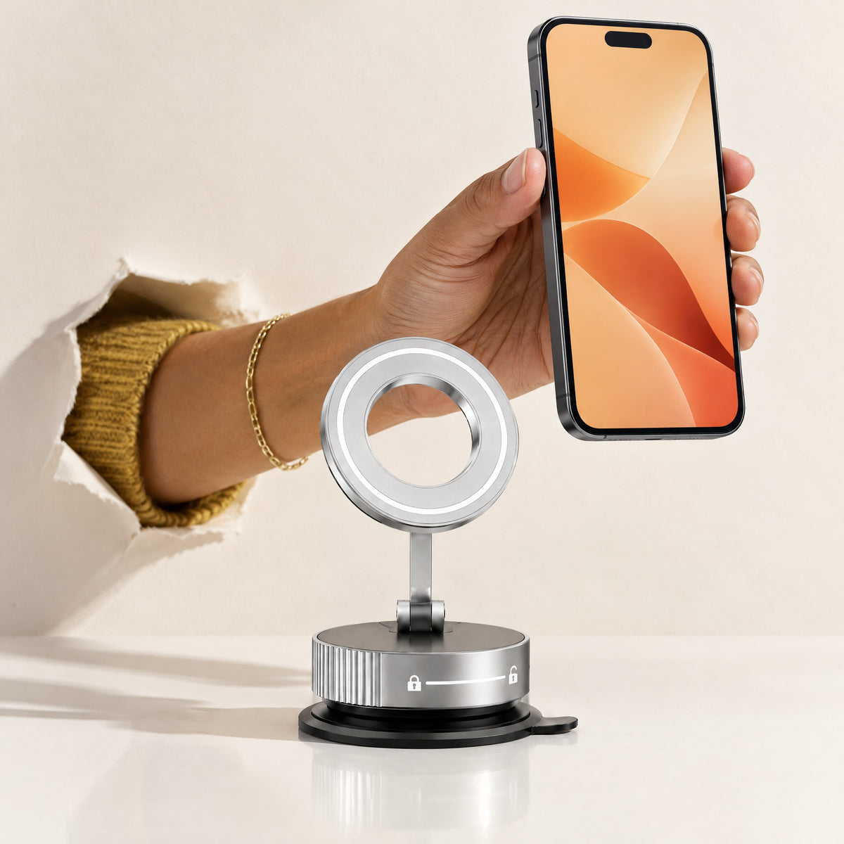 A hand reaching out of a torn paper backdrop lifts a phone off the silver Limpet mount, showing its ring-shaped magnetic head