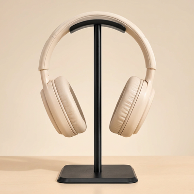 Black aluminium headphone stand holding cream headphones