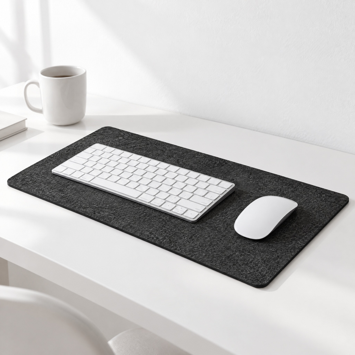 Felt desk mat in dark grey on a white desk