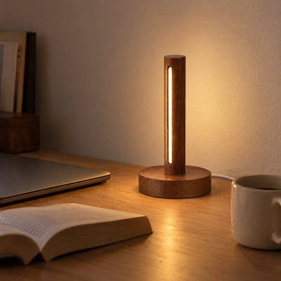 Ember walnut lamp glowing warm on a desk in the evening