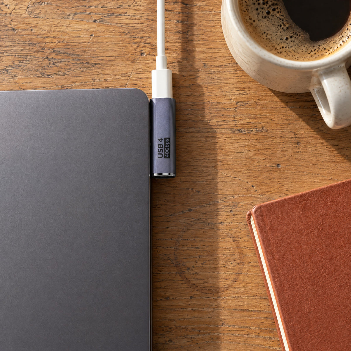 Top-down view of a Long Side-Out USB-C adapter in a laptop's side port, the cable running along the laptop edge