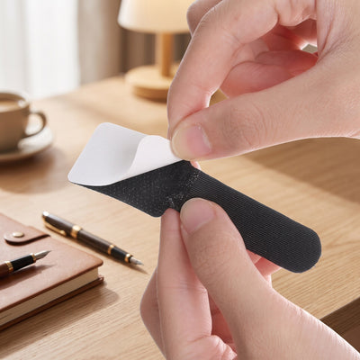 Peeling the white backing off the adhesive pad of a black Velor cable tie