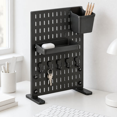 Black Trellis desk pegboard with a tray, a pencil bin and five hooks on a white desk behind a keyboard