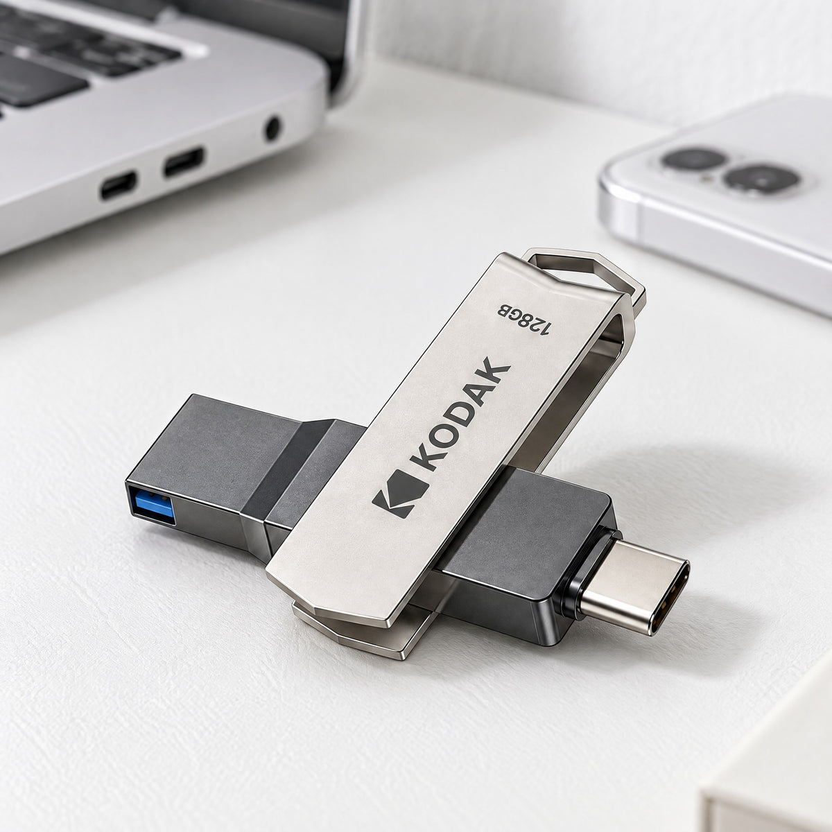 Ferry swivel flash drive with its silver cover turned open, showing the USB-A and USB-C plugs, on a white desk