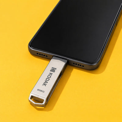 Ferry flash drive plugged into the USB-C port of a phone on a yellow surface