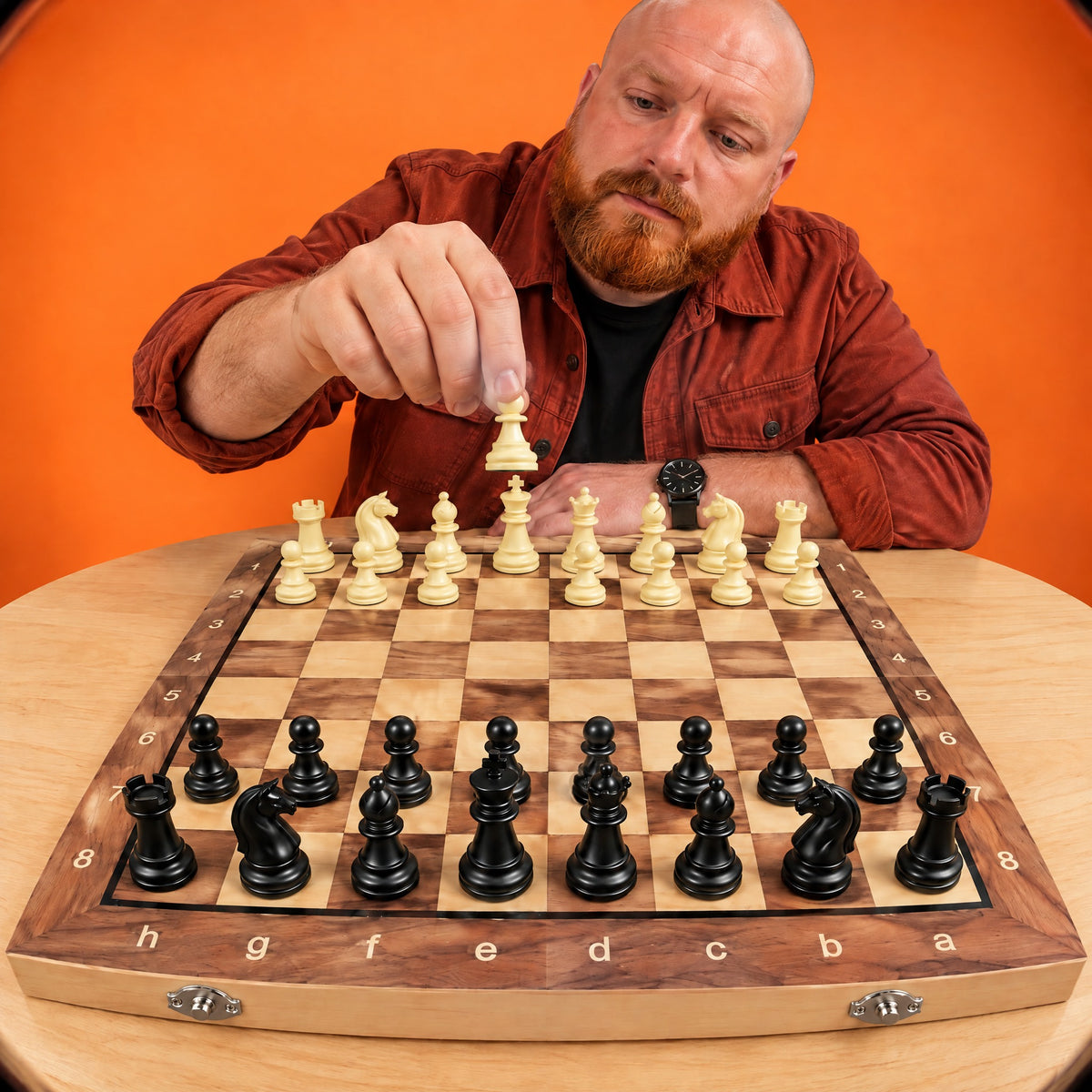 Man moving a cream pawn on the Gambit wooden chess board, seen through a wide lens