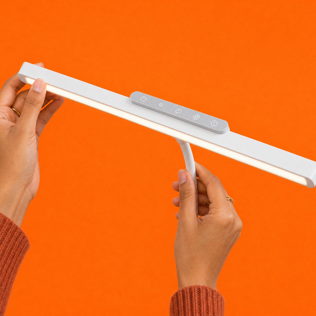 Hands tilting the white Heron light bar, with its light grey touch panel