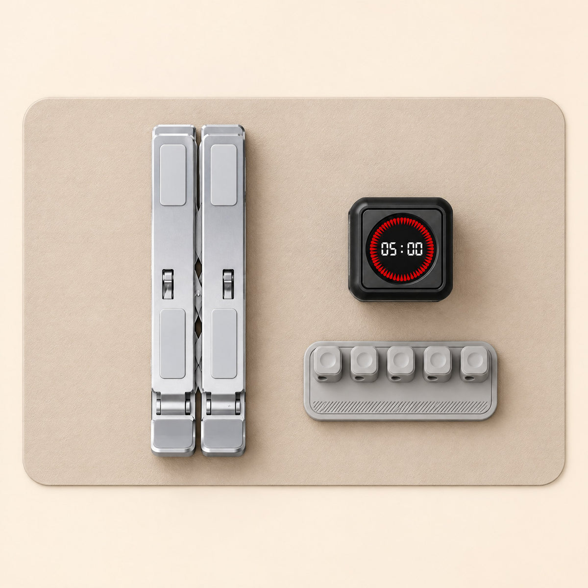 Desk mat, folded laptop stand, cube timer and cable holder laid out from above