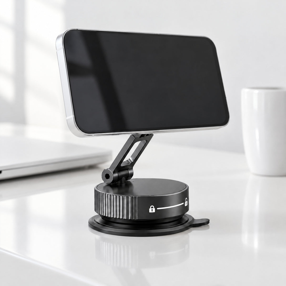 Limpet folding suction phone mount in black on a glossy white desk, holding a phone sideways