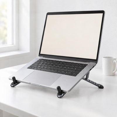 Silver laptop raised on the Span folding aluminium stand on a white desk