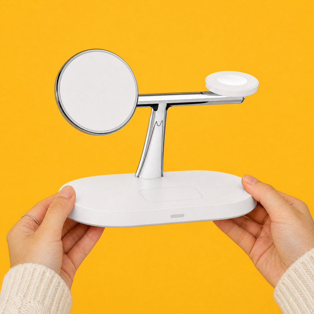 Two hands holding the empty white Trio charging stand by its base against a yellow backdrop